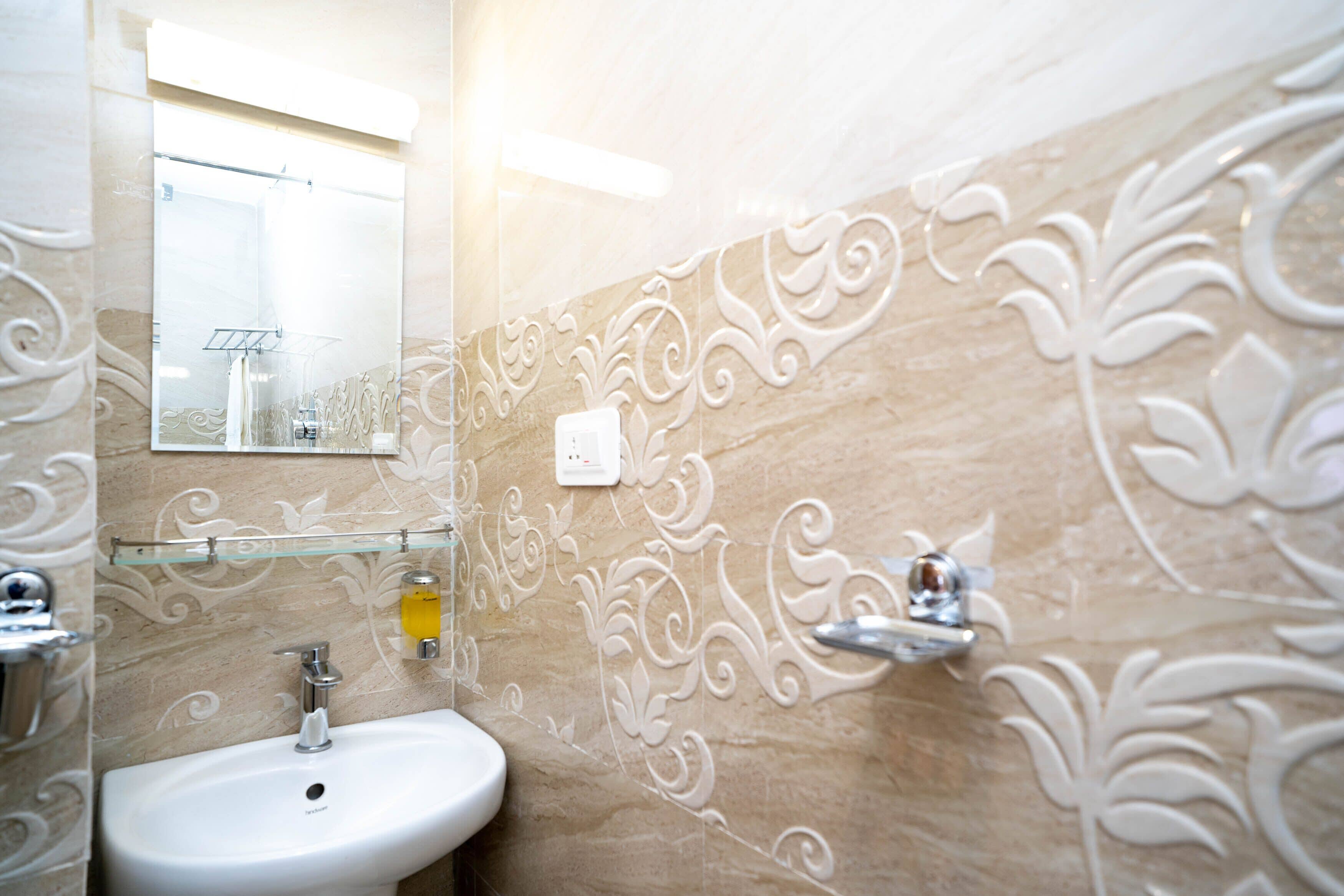 A bathroom with a white sink, a mirror, and decorative wall patterns.