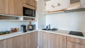 A modern kitchen with wooden cabinets, a microwave, a kettle, and a sink. - "Charming Studio in Central Arcachon with Balcony, Steps from Beach - Sleeps 2" (Arcachon)