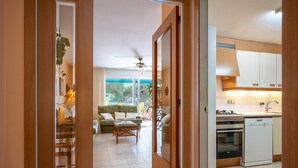 A modern kitchen with white cabinets, a dishwasher, and a stove. - Seaside Apartment with Parking and AC (Torredembarra)