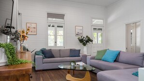 Un salon moderne avec un canapé gris, une table basse en verre et un meuble en bois.