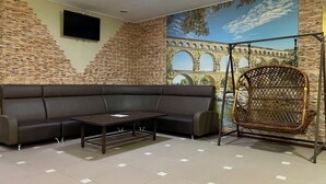 Una sala de estar moderna con un sofá seccional, una mesita y un sillón colgante de mimbre.