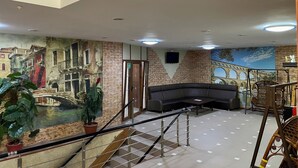 Un vestíbulo con un mural de un puente, una escalera y una zona de estar.