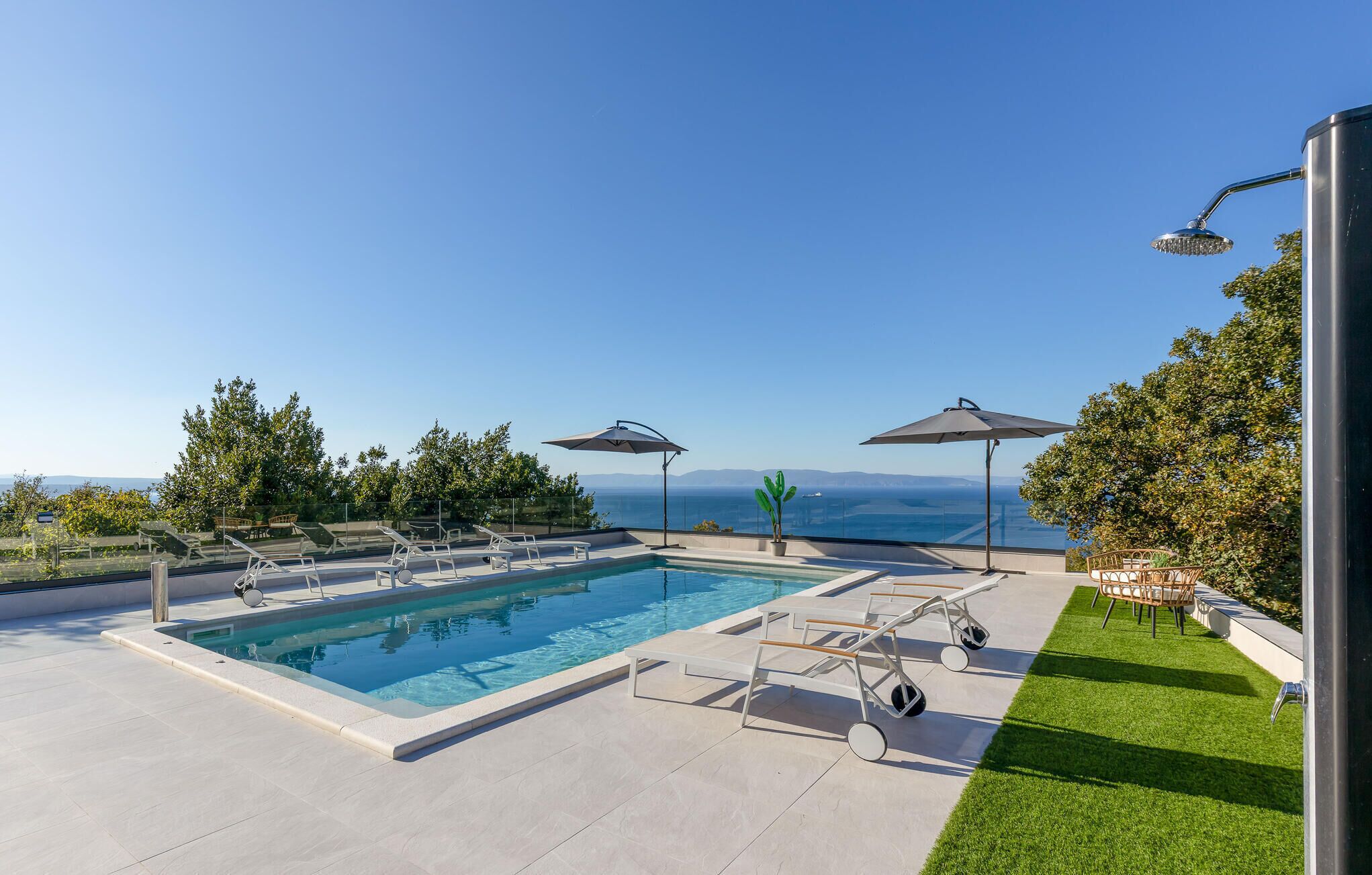 Una piscina rectangular amb un cel blau clar al fons.