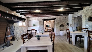 A rustic dining area with stone walls, wooden tables, and chairs. - Castello Gulich (Porec)