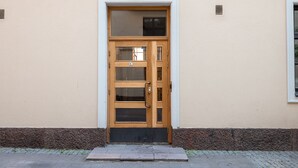 Une porte double en bois avec des panneaux de verre, un petit auvent et une boîte aux lettres placée au-dessus.