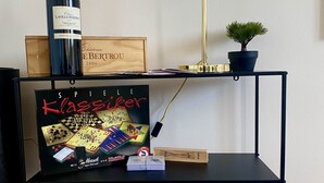A black metal shelf with a wine bottle, a chessboard, and a small potted plant. - Schängel Chic apartment centrally located in the old town (Koblenz)