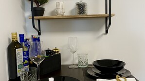 A dining setup with black plates, gold cutlery, and a tea sign on a shelf. - Schängel Chic apartment centrally located in the old town (Koblenz)