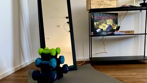 A room with a yoga mat, dumbbells, and a shelf with a framed certificate and a book. - Schängel Chic apartment centrally located in the old town (Koblenz)