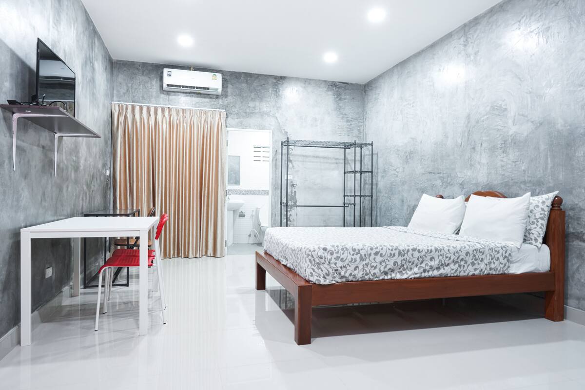 Un dormitorio con cama, escritorio, silla y armario.