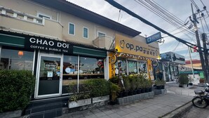 A coffee shop named Chao Doi with a sign for op.pa, a restaurant, and a sign for Guest House. - Guesthouse Phuket Airport (Sa Khu)