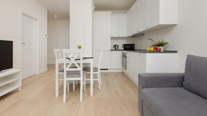 A modern apartment with a dining area, kitchen, and living room. - Family Apartment with Parking | Balcony and Workspace (Warszawa)