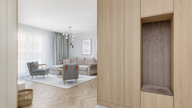 A modern living room with a sofa set, two armchairs, a coffee table, and a decorative chandelier. - Elegant Apartment on Salt Island | Parking | Balcony (Kolobrzeg)