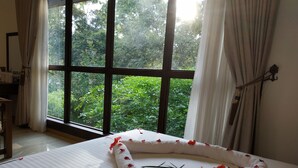 Una stanza con un'ampia finestra, un letto con petali di rosa e una decorazione a stella.
