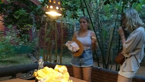 Un tavolo con un cesto di pannocchie e una bottiglia.