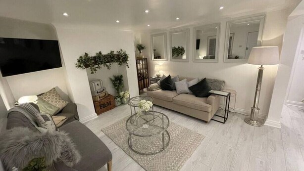 Un salon moderne avec un canapé, une table basse en verre et un lampadaire.