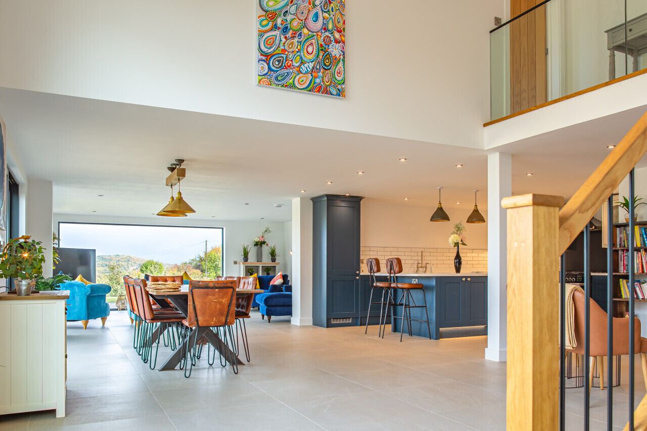 Een ruime, open woonkamer met een eettafel, keuken en zithoek.
