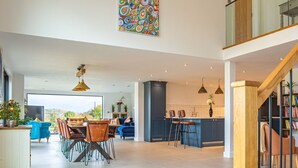 Een ruime, open woonkamer met een eettafel, keuken en zithoek.
