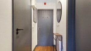 A hallway with a closed door, a radiator, and a small table.