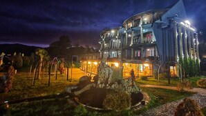 Ein mehrstöckiges Hotel mit Steinverkleidung, Außenbereich und einem angelegten Garten.