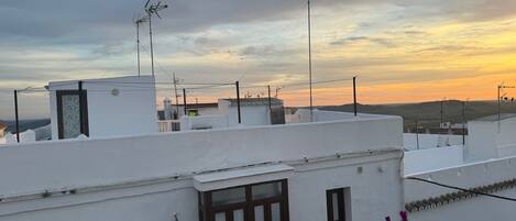 A rooftop with white buildings, multiple antennas, and a clear sky.