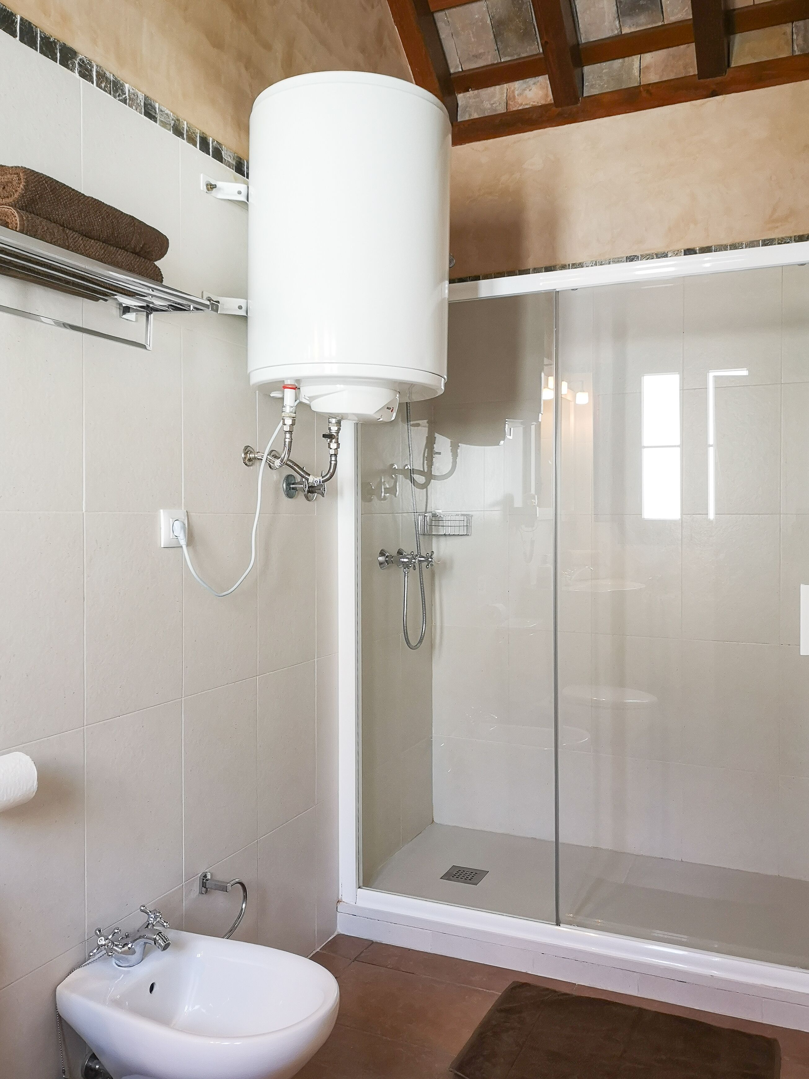 Un baño con ducha de vidrio, lavamanos blanco y un inodoro.