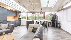 A modern kitchen with a dining area, a sofa, and a bar area.