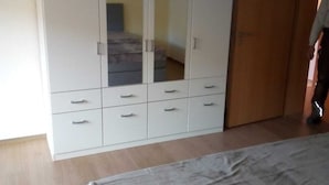 Makuuhuoneessa on suuri vaatekaappi, sänky ja puuovi.