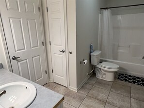 Une salle de bain comprenant des toilettes, un lavabo et un espace douche.