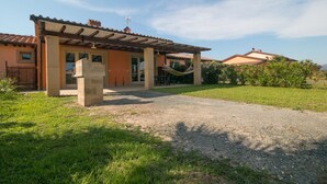 A house with a covered patio, a hammock, and a gravel driveway. - Limonaia, one-bedroom terraced house PLUS (Cecina)