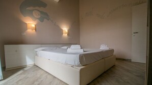 Ein Schlafzimmer mit einem großen Bett, zwei Wandleuchten und einer Tür.