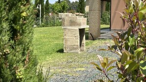Uma construção de pedra num jardim sob um céu claro.
