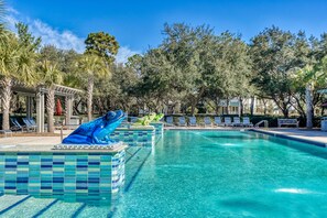 A swimming pool with a frog statue, lounge chairs, and trees in the background. - Lake District Luxury: 6-Bedroom Retreat with WaterColor Beach Club Access, Bikes, and Electric Cart! (Santa Rosa Beach)