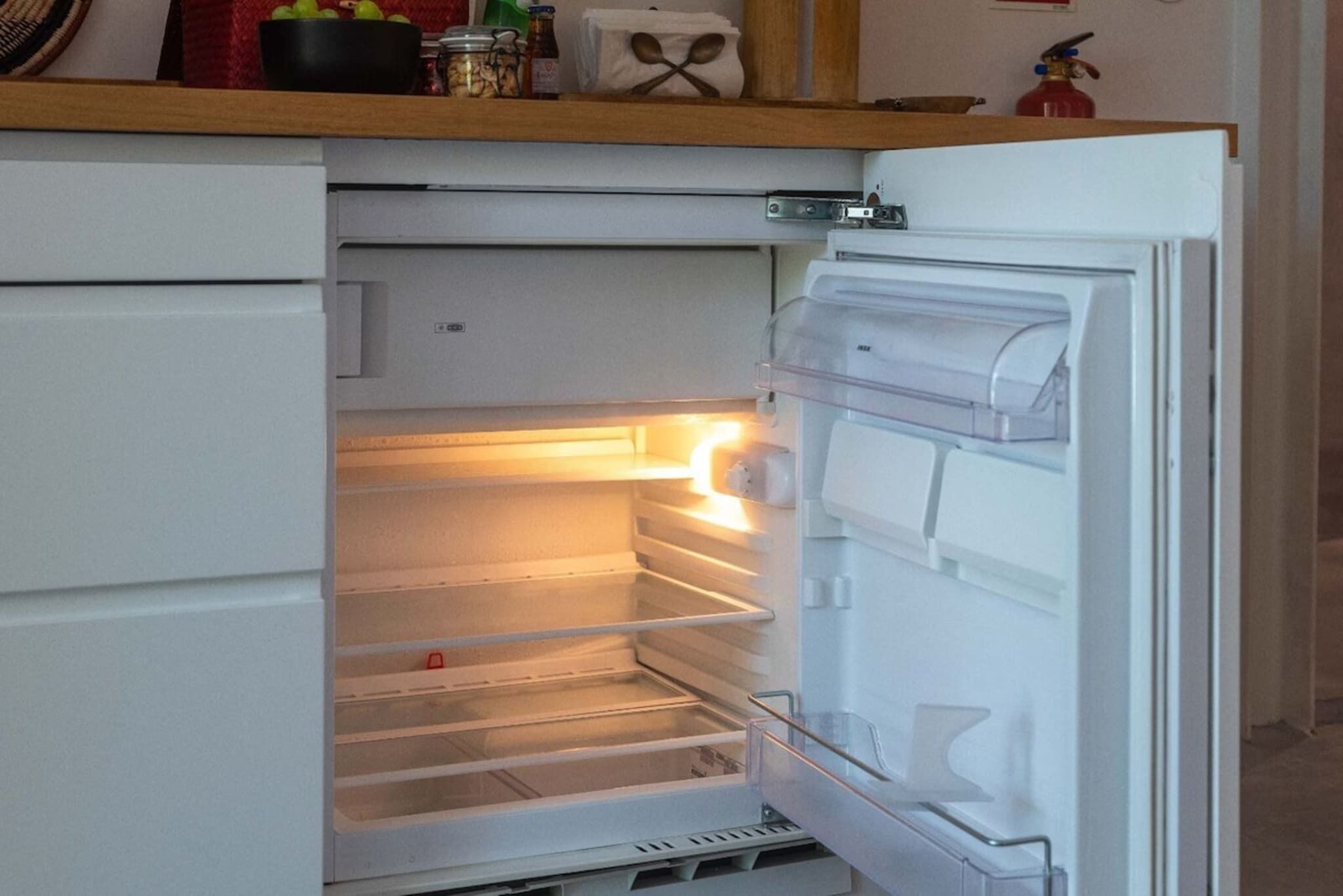 An open refrigerator with shelves and a freezer compartment.