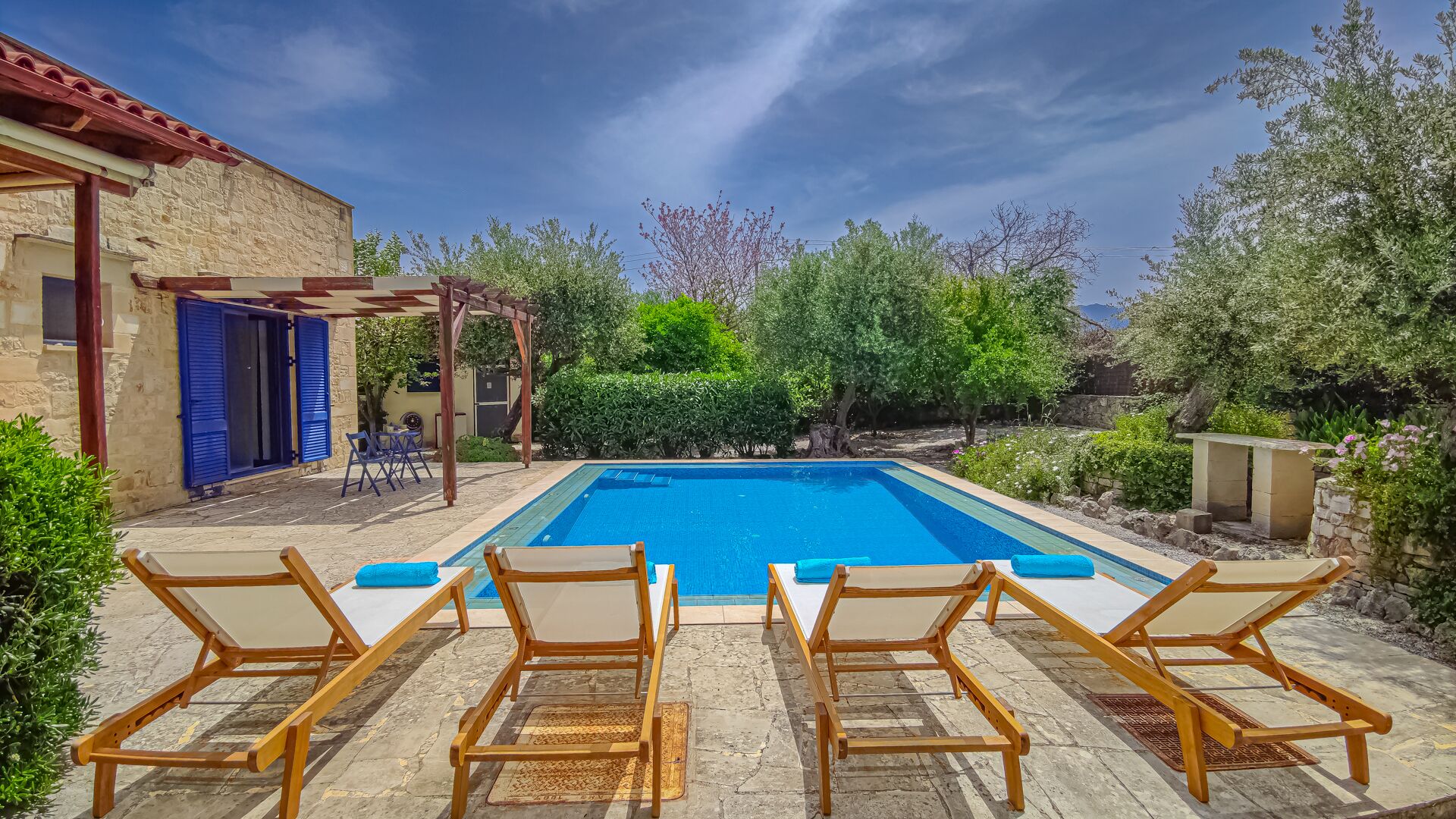 A swimming pool with lounge chairs and a pergola.