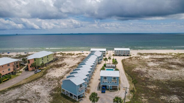 Un hotel costero con varias construcciones, una playa y el océano.