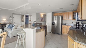 A modern kitchen with a central island, stainless steel appliances, and wooden cabinets. - Avalon 507-Oceanside 140th St, Free WiFi, Pool, Elev, W/D, AC (Ocean City)