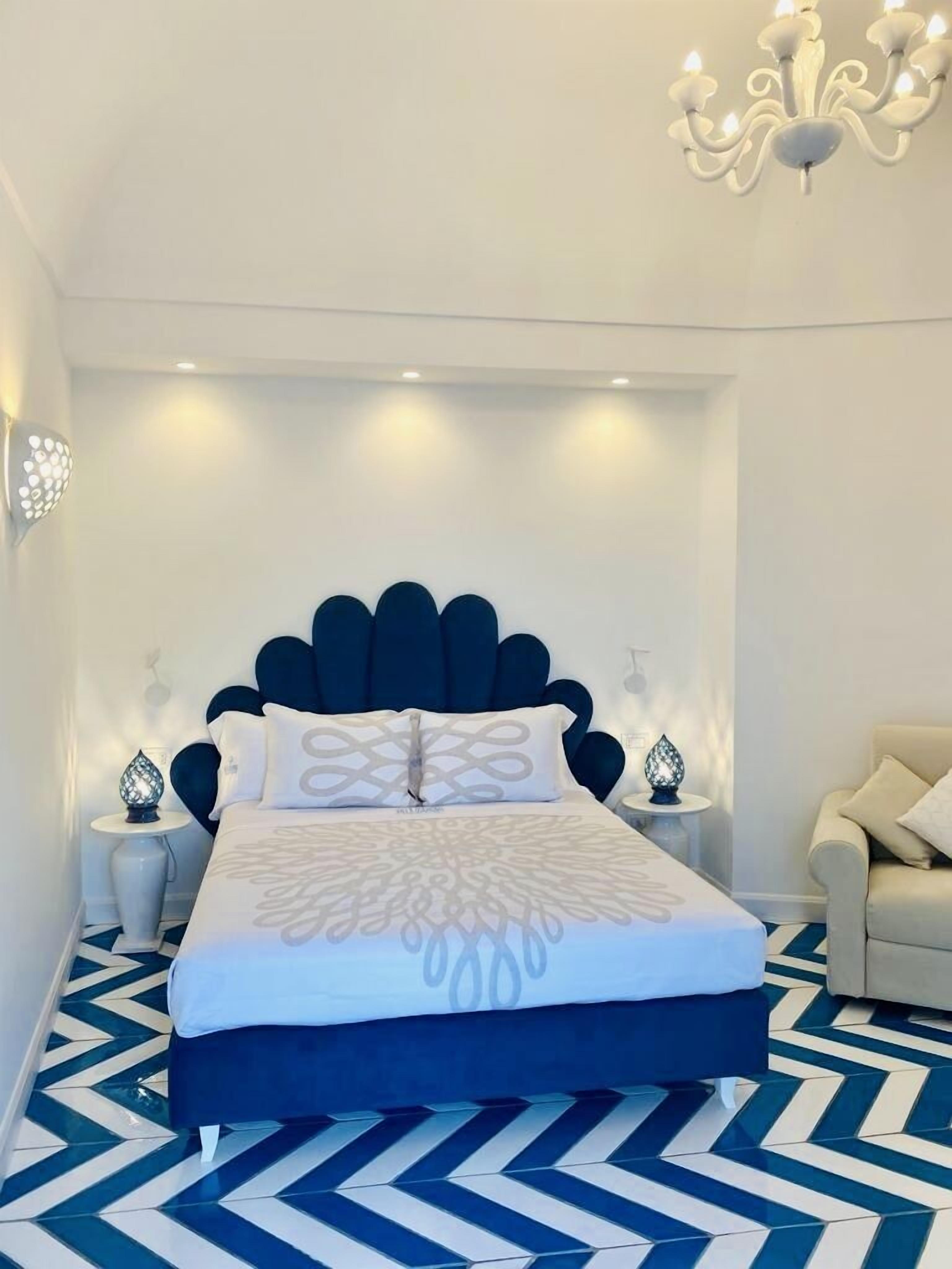 Un dormitorio moderno con una cama grande, una araña y un suelo estampado.