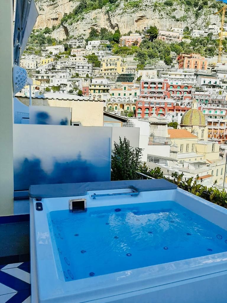A hot tub with a view of a hillside town.