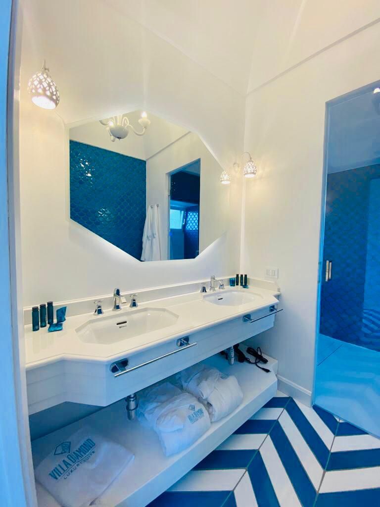 A bathroom with two sinks, a large mirror, and a shower area.