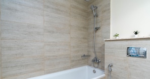 A bathroom with a bathtub, a shower, and a wall-mounted towel rack. - Deluxe 1 BR in Oasis - 43 (Abu Dhabi)