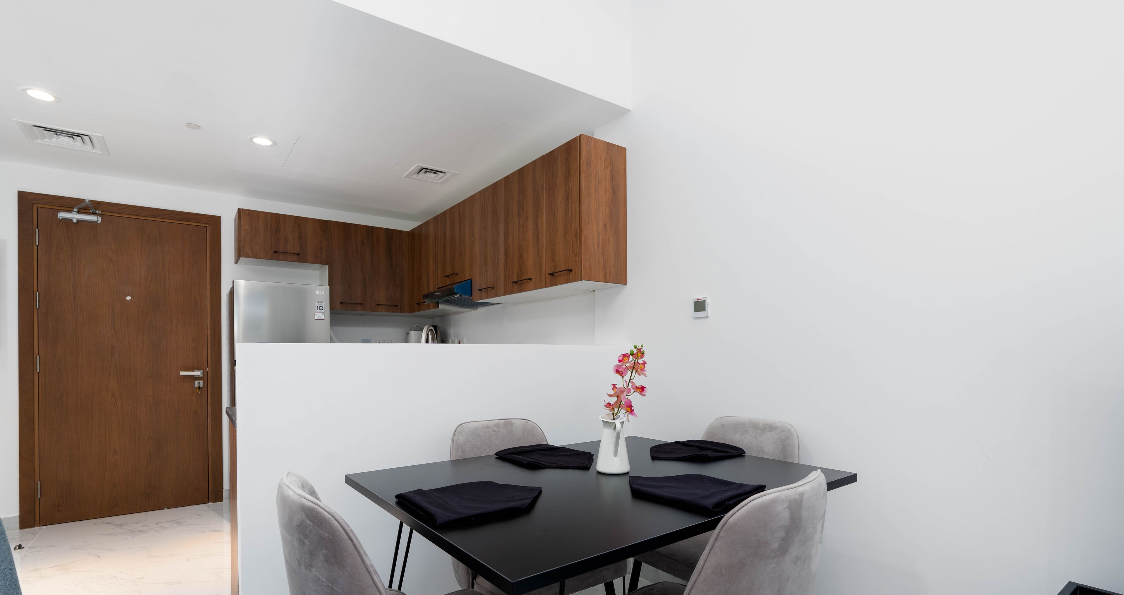 A modern kitchen with wooden cabinets and a dining area with a table and chairs.
