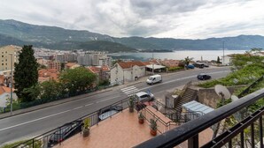 A coastal cityscape with a road, buildings, and mountains in the background. - Sea view studio Tibor (Budva)