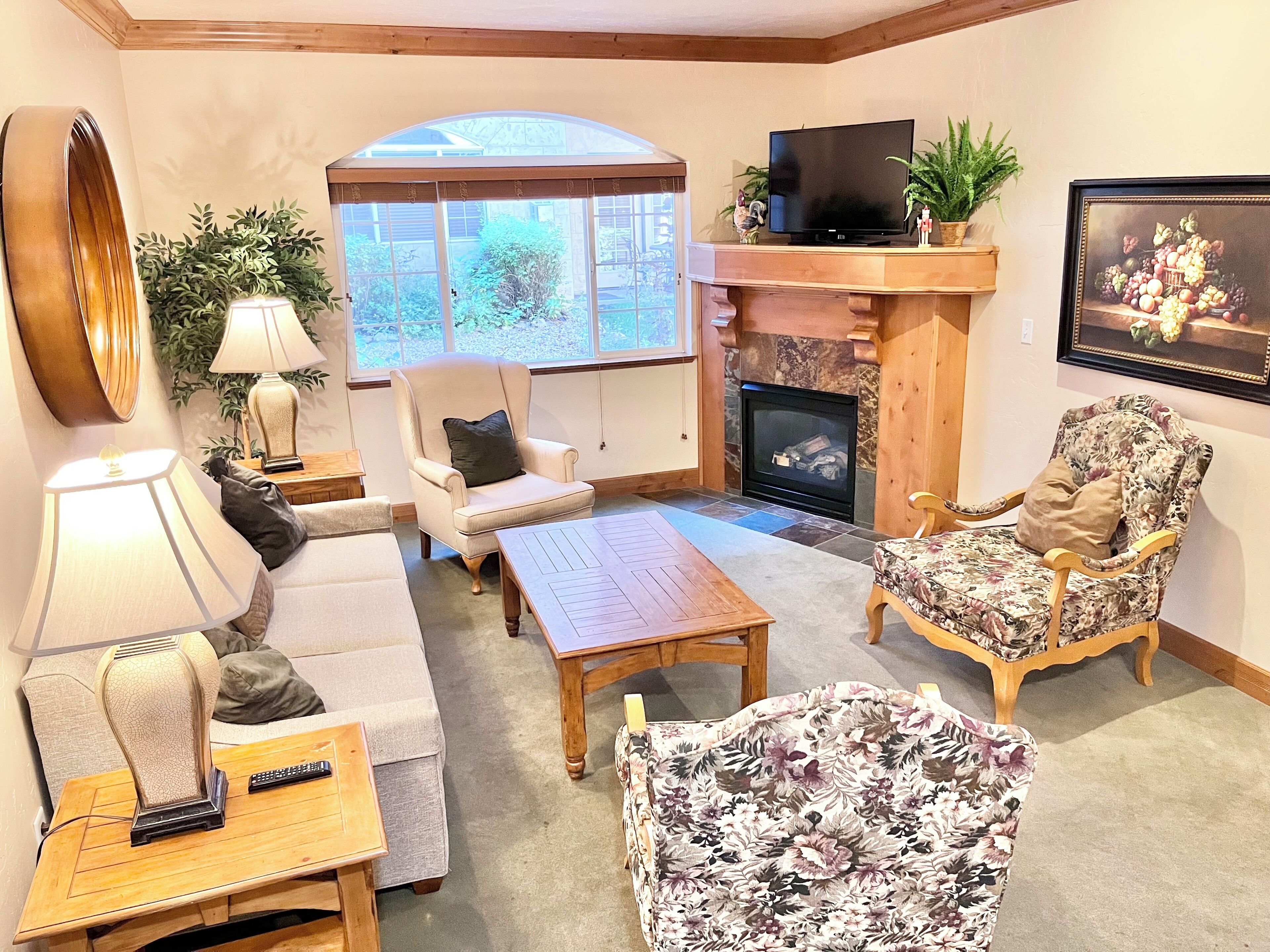 A cozy living room with a fireplace, comfortable seating, and a television.
