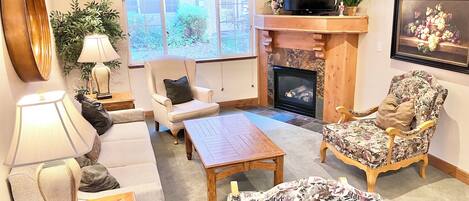 A cozy living room with a fireplace, comfortable seating, and a television.