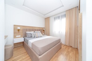 A modern bedroom with a large bed, wooden headboard, bedside tables, and a nightstand.