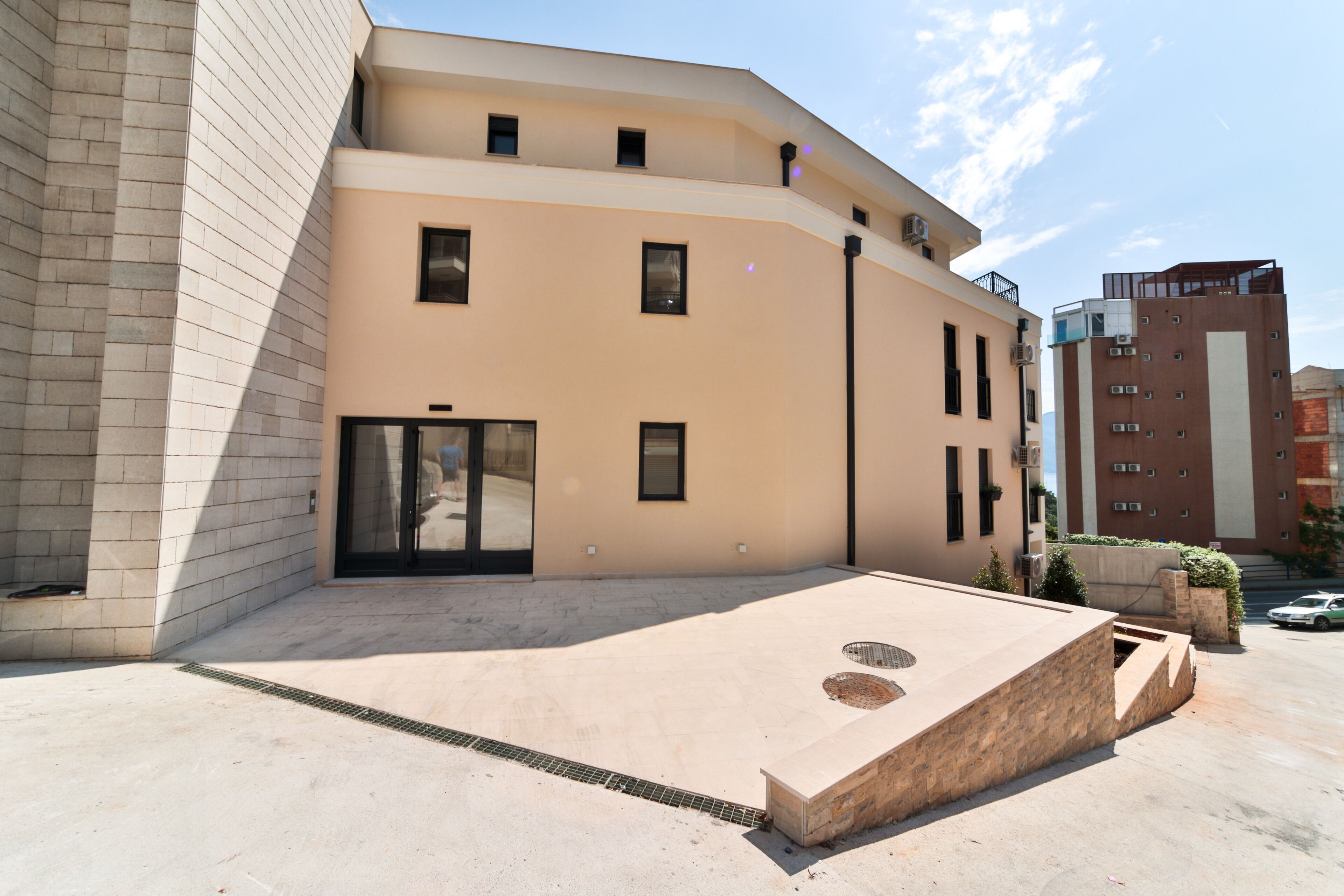 A modern building with a flat roof, large windows, and a small entrance.