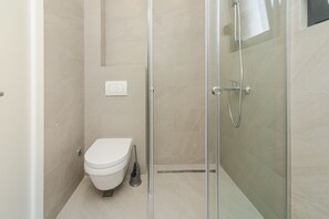 Apartemen Deluks | Kamar mandi | Shower, pengering rambut, handuk, dan tisu toilet