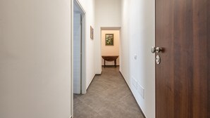 Ein Flur mit einer Holztür, einem Tisch und einem gerahmten Bild an der Wand.