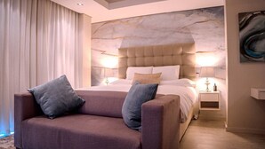 Un dormitorio moderno con una cama grande, dos mesitas de noche y un sofá.