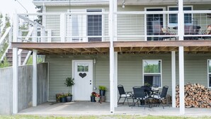 A two-story house with a covered porch, a door with a heart-shaped decoration, and a stack of firewood. - Quiet farm stay, hike, mushroom hunt, see the animals, relax, so much more! (Edmonton)